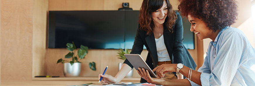 Creative female executives using digital tablet in office.